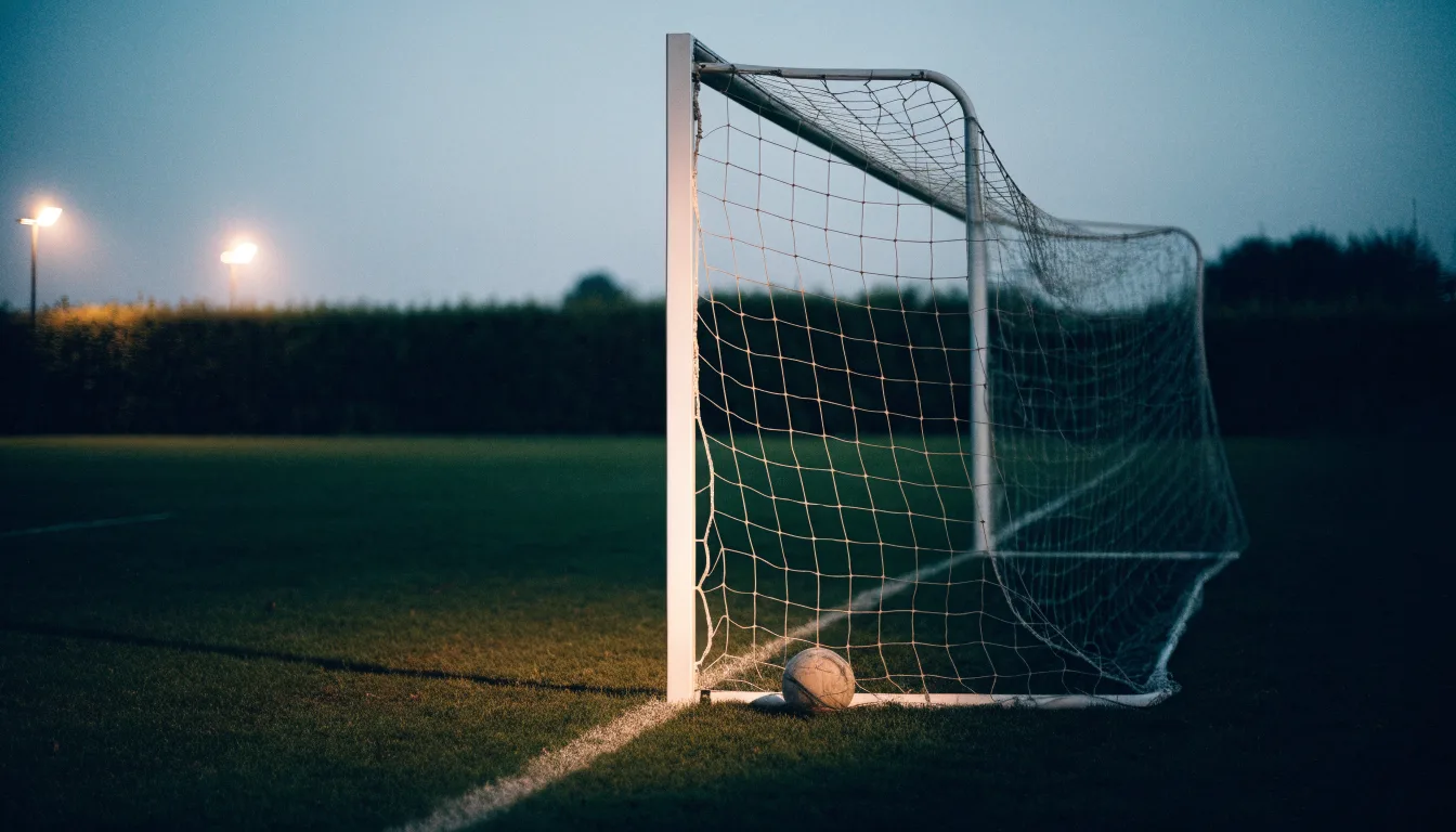 Ein Fussballtor mit locker hängendem Netz auf einem Trainingsplatz, das sich leicht im Wind bewegt.